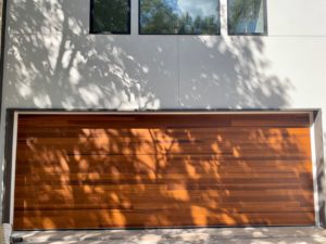 Fratex wooden garage door white stucco home